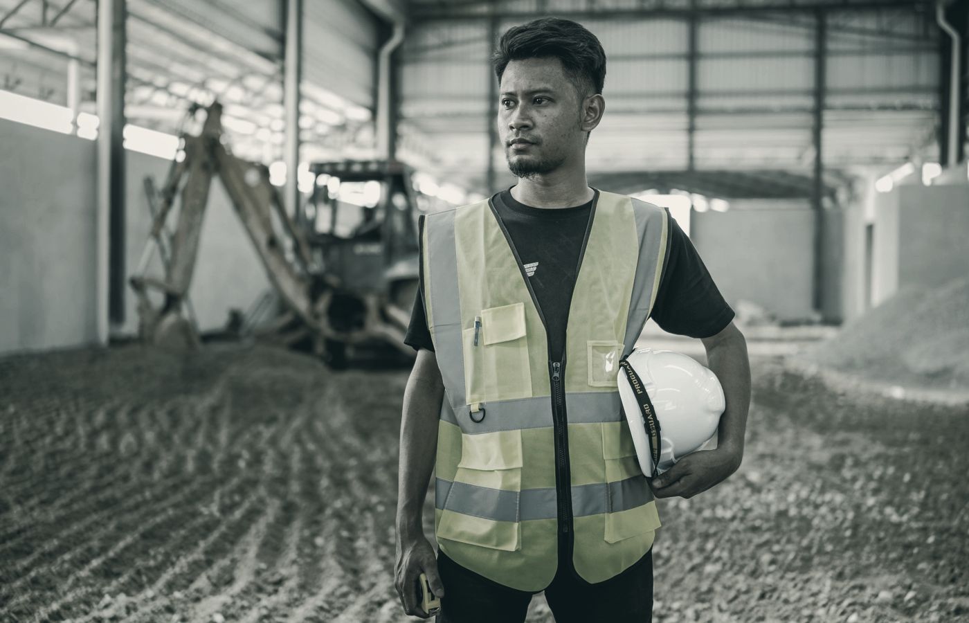 Contractor on a construction site, helmet under his arm